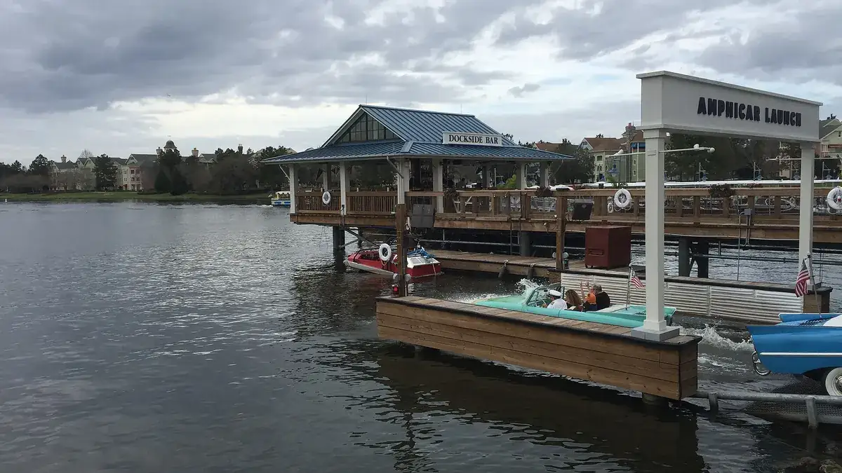 An Amphicar driving down the launch ramp into the lake at The Boathouse, Disney Springs